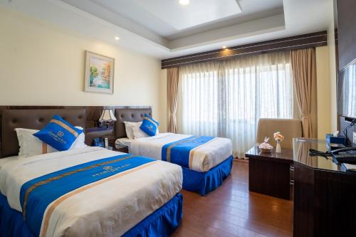 a hotel room with two beds and a television at Shangrila Blu Hotel in Kathmandu