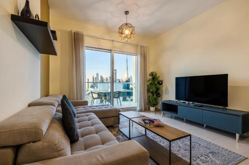 a living room with a couch and a flat screen tv at Unlock Metropolis Business Bay in Dubai