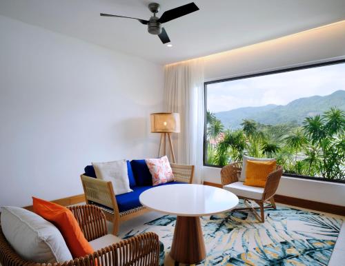 a living room with a table and chairs and a large window at laïla, Seychelles, a Tribute Portfolio Resort in Mahe