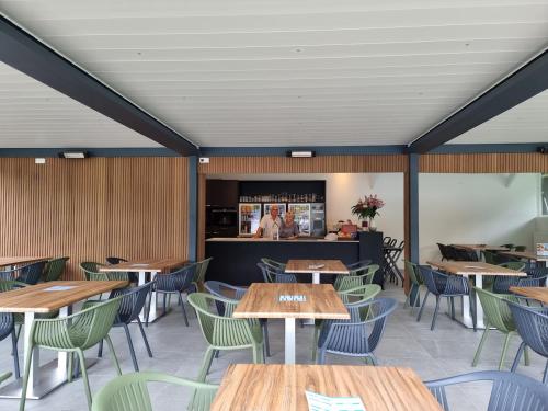 een eetkamer met houten tafels en stoelen bij Vakantiepark Breebos in Rijkevorsel