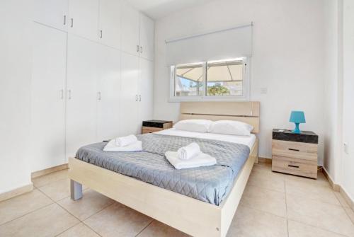 a bedroom with a bed with two towels on it at Lindos Villa Ekaterina in Paralimni