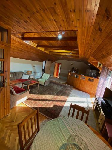 a living room with wooden ceilings and a couch at Apartman Trebinje in Trebinje