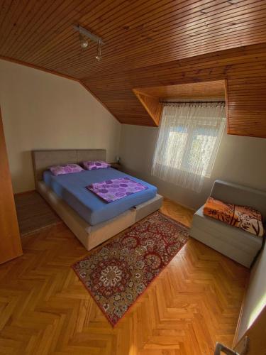 a bedroom with a bed and a window and a rug at Apartman Trebinje in Trebinje