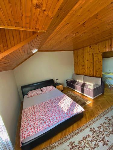 - une chambre avec un grand lit et un plafond en bois dans l'établissement Apartman Neno, à Trebinje