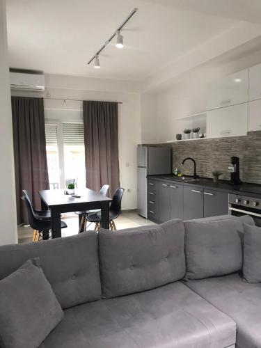 a living room with a couch and a kitchen with a table at Apartments IVI Gevgelija in Gevgelija