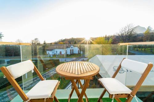 a table and two chairs sitting on a balcony at Aparthotel Belveder in Tatranská Lomnica