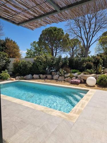 une piscine dans une cour avec un parasol dans l'établissement Magnifique Villa avec Piscine en Provence, à Verquières