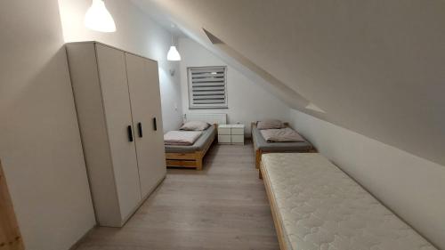 Zimmer im Dachgeschoss mit 2 Betten und einer Treppe in der Unterkunft Agroturystyka Romanówka w Krzeszowie in Krzeszów