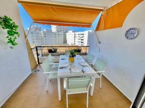 uma sala de jantar com uma mesa e cadeiras numa varanda em GATU PREMIUM Villa Poniente, junto la playa de Valdelagrana em El Puerto de Santa María