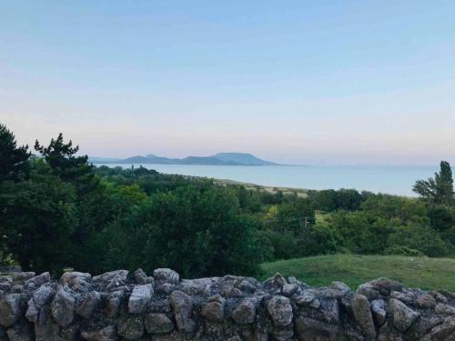 a stone wall with a view of the ocean at Kis Pele nyaraló in Balatongyörök