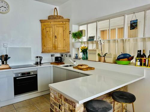 a kitchen with white cabinets and a white counter top at Larkin House in Rye