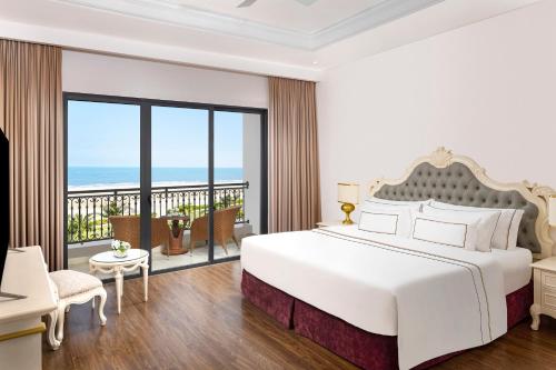 a bedroom with a large bed and a balcony at Vinpearl Cua Hoi, Affiliated by Melia in Cửa Lò