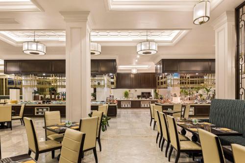 a restaurant with tables and chairs and a kitchen at Vinpearl Cua Hoi, Affiliated by Melia in Cửa Lò