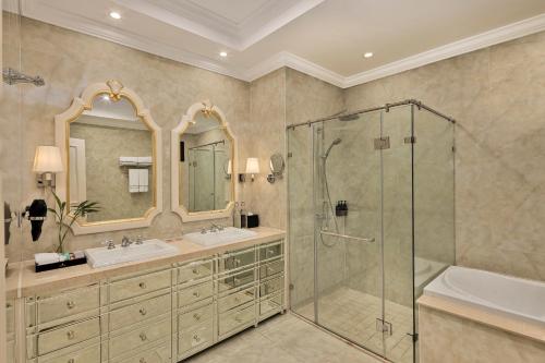 een badkamer met een douche, een wastafel en een bad bij Melia Vinpearl Cua Hoi Beach Resort in Cửa Lô