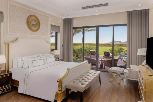 a bedroom with a white bed and a living room at Melia Vinpearl Cua Hoi Beach Resort in Cửa Lò