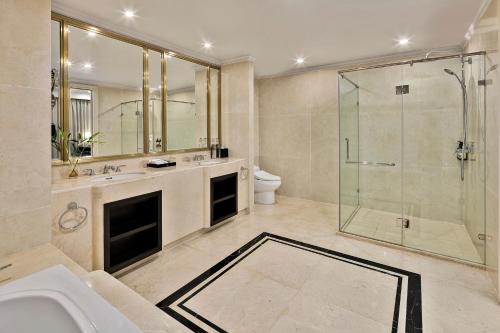 a bathroom with a shower and a sink and a toilet at Vinpearl Cua Hoi, Affiliated by Melia in Cửa Lò