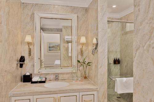 a bathroom with a sink and a mirror at Vinpearl Cua Hoi, Affiliated by Melia in Cửa Lò