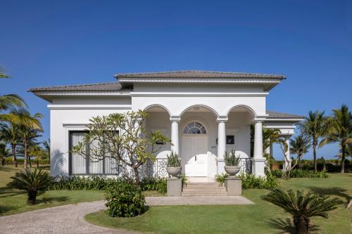 a white house with palm trees in front of it at Vinpearl Cua Hoi, Affiliated by Melia in Cửa Lò