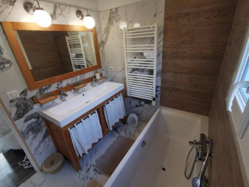 a bathroom with a sink and a mirror and a tub at Villa avec vue entre Mer et Lac in Ampus