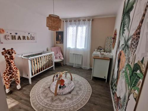 a baby room with a crib and a table at Villa avec vue entre Mer et Lac in Ampus