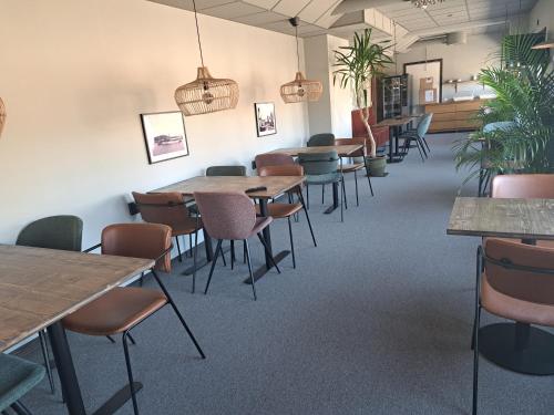 Kramfors Stadshotell AB في كرامفورس: غرفة طعام مزودة بالطاولات والكراسي والنباتات الفخارية