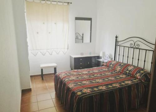 1 dormitorio con cama, mesa y espejo en Dama Rural, en Posadas