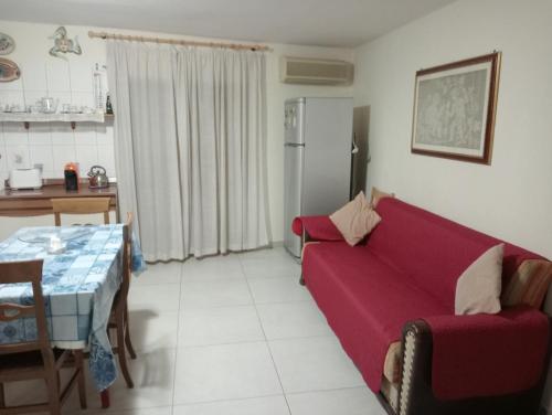 a living room with a red couch and a table at Casa Agatina in Catania