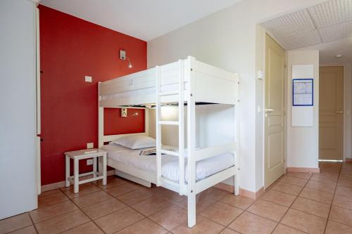 a white bunk bed in a room with red walls at Résidence Pierre & Vacances le Hameau de la Pinède in Hyères