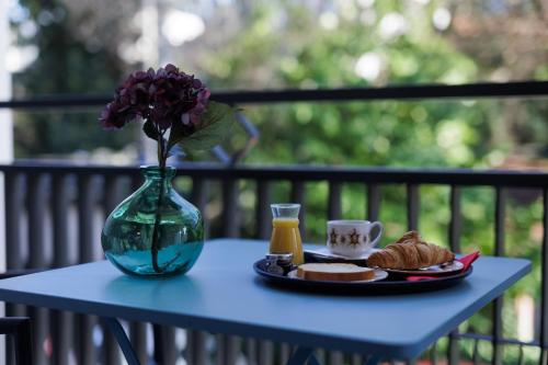 einem blauen Tisch mit einem Teller Essen und einer Vase in der Unterkunft Aix-les-Bains Appart'S in Aix-les-Bains