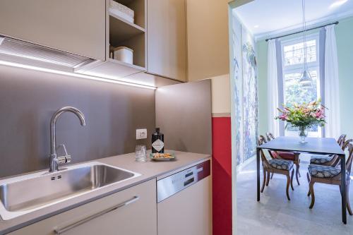 eine Küche mit einem Waschbecken und einem Tisch mit Stühlen in der Unterkunft Ca' Margherita Secret Garden in Venedig