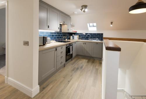 a kitchen with white cabinets and blue tiles at Stroan in New Galloway