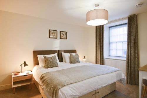 een slaapkamer met een groot bed en een raam bij Stroan in New Galloway