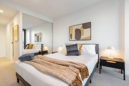 1 Schlafzimmer mit 2 Betten und einem großen Spiegel in der Unterkunft Walk to the Grand Prix track - Albert Park in Melbourne