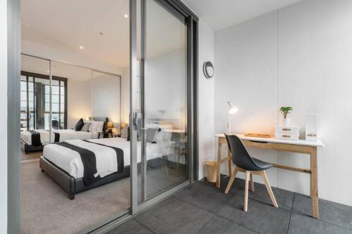 a bedroom with a bed and a table and a desk at Lovely 1-bedroom apartment - 0177 in Melbourne
