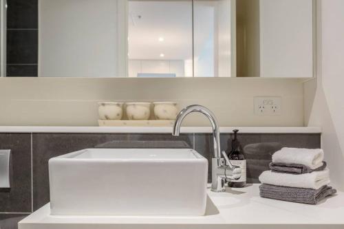 a white kitchen with a sink and a counter top at Lovely 1-bedroom apartment - 0177 in Melbourne