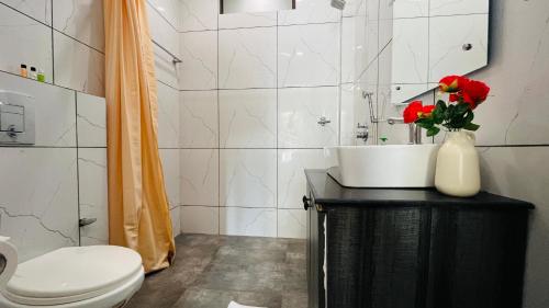 a bathroom with a toilet and a sink and red roses at BluO Studio DLF CyberCity - Kitchen, Balcony, Lift in Gurgaon