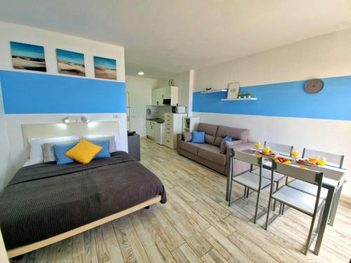 ein Schlafzimmer mit einem Bett, einem Tisch und einer Couch in der Unterkunft Blue Vista Studio Paraiso in Adeje