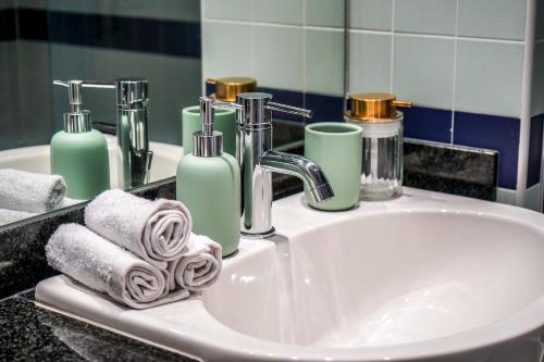 a bathroom sink with towels and soap and a mirror at Charming Duplex in Grand Canal in Dublin