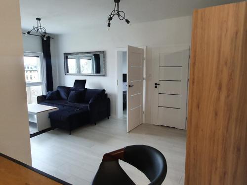 sala de estar con sofá negro y silla negra en Apartament Business Sienkiewicza, en Leszno