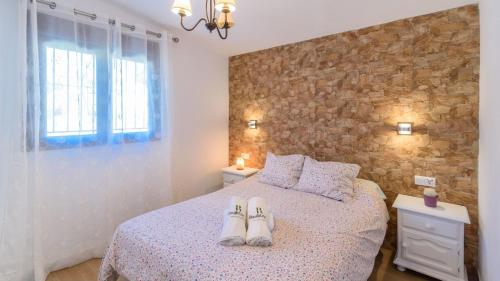 a bedroom with a bed with two pairs of shoes on it at Casa El Refugio de Árchez by Ruralidays in Árchez