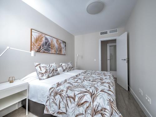 a white bedroom with a bed and a desk at New beach front apartment with large balcony in Torrox Costa