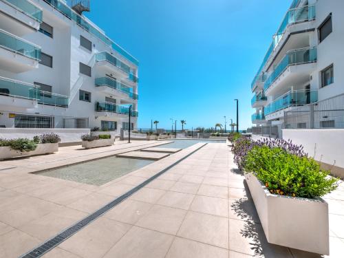 a sidewalk in front of a building with plants at New beach front apartment with large balcony in Torrox Costa