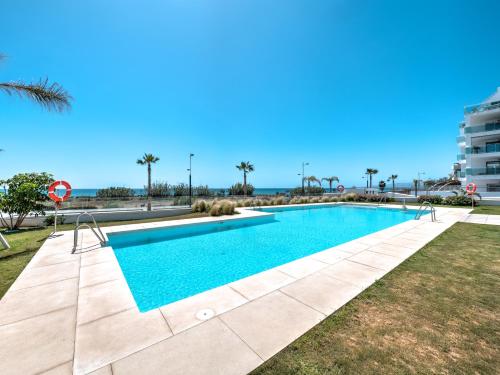 a swimming pool with the ocean in the background at New beach front apartment with large balcony in Torrox Costa