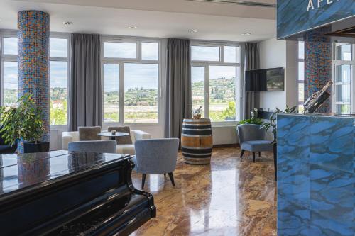 a lobby with a piano and a living room at Hotel Oleander - Oleander Resort in Strunjan