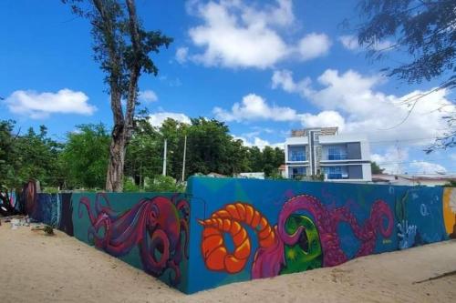 Relax in front of beach! 3 bd condo with rooftop! في ريو سان خوان: حاجز أزرق عليه لوحة جدارية ملونة