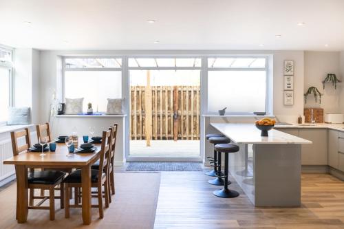 a kitchen and dining room with a table and chairs at Amazing New Spacious Apartment in SE1 in London