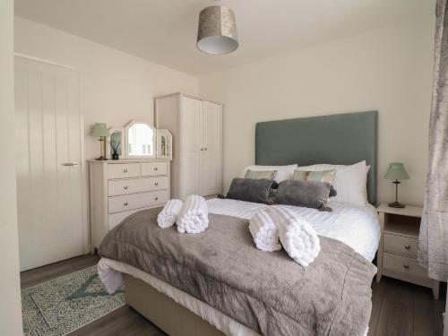 um quarto com uma cama grande com duas almofadas em The Old Coach House em Conwy