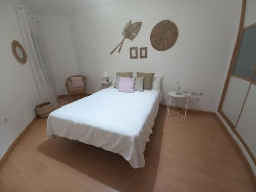 een witte slaapkamer met een groot wit bed en een tafel bij Cantabrico playa Grupo AC Gestion in Cádiz