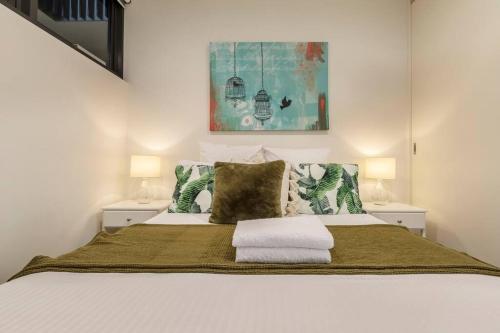 1 dormitorio con 1 cama blanca grande y 2 lámparas en Walk to the Grand Prix Track 01583, en Melbourne