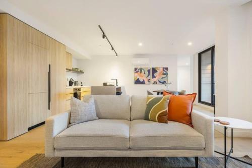 a living room with a couch with colorful pillows at Lovely 2-bedroom with free parking - 03224 in Melbourne